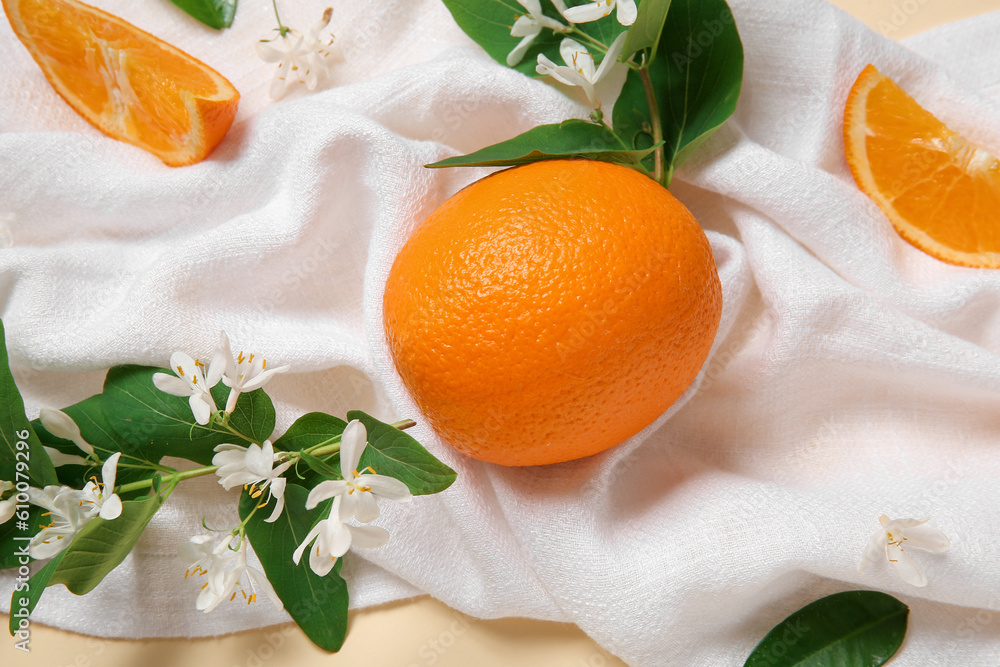 Oranges with blooming branches on beige background