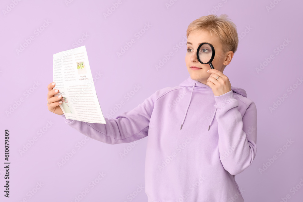 Young woman with magnifier reading newspaper on lilac background