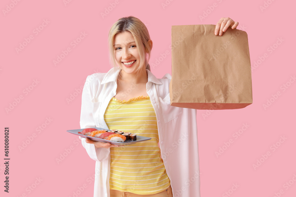 Young woman with sushi and paper bag on pink background