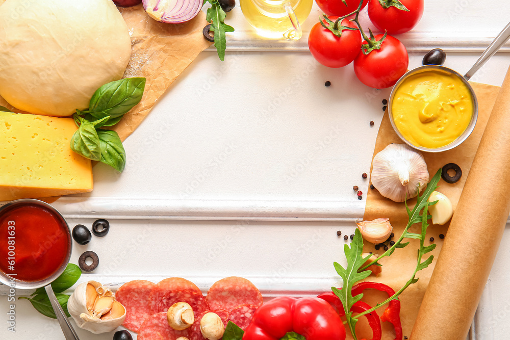 Frame made of raw dough and ingredients for preparing pizza on white background