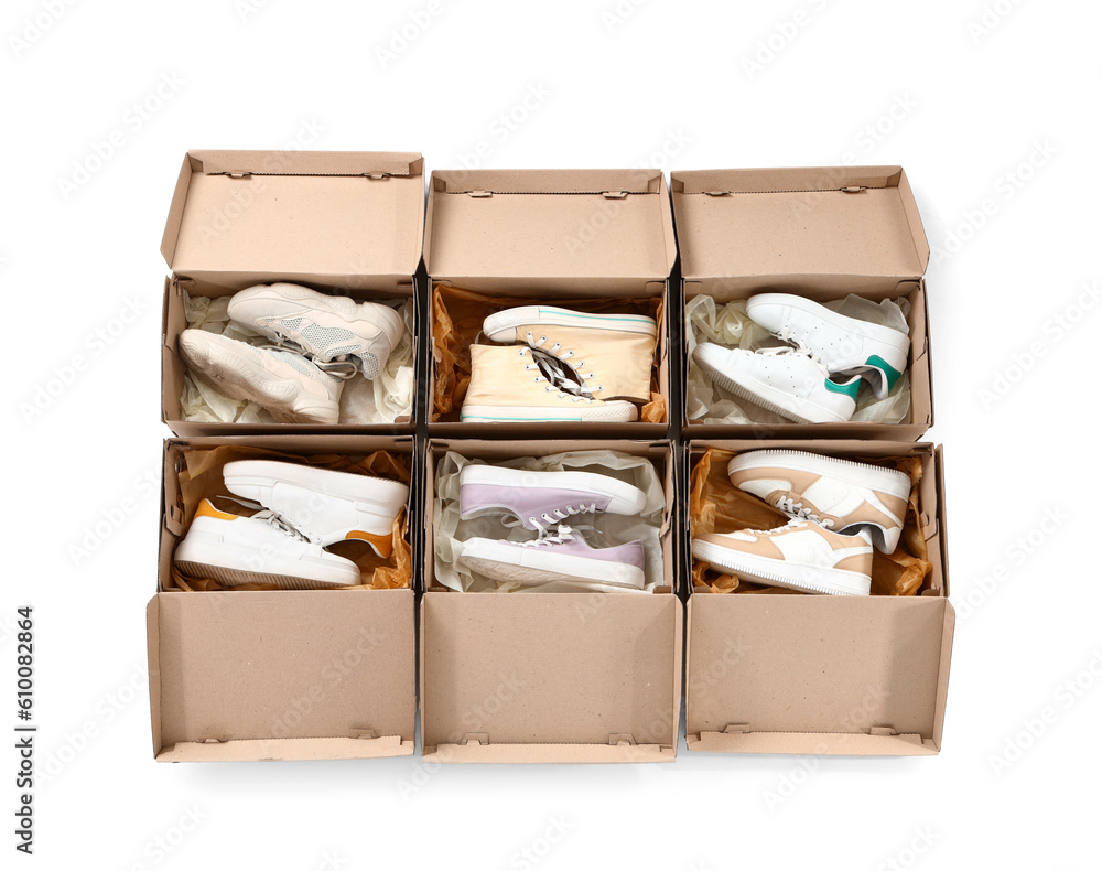 Cardboard boxes with different stylish sneakers on white background