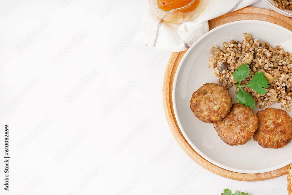 Cutlets with buckwheat, mushrooms and parsley on white table in kitchen