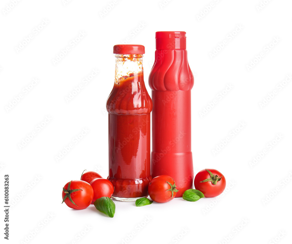 Bottles of ketchup and tomatoes on white background