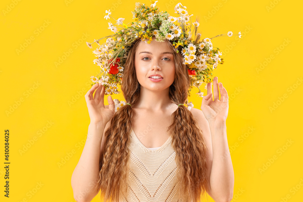 Beautiful young woman in flower wreath on yellow background. Summer solstice