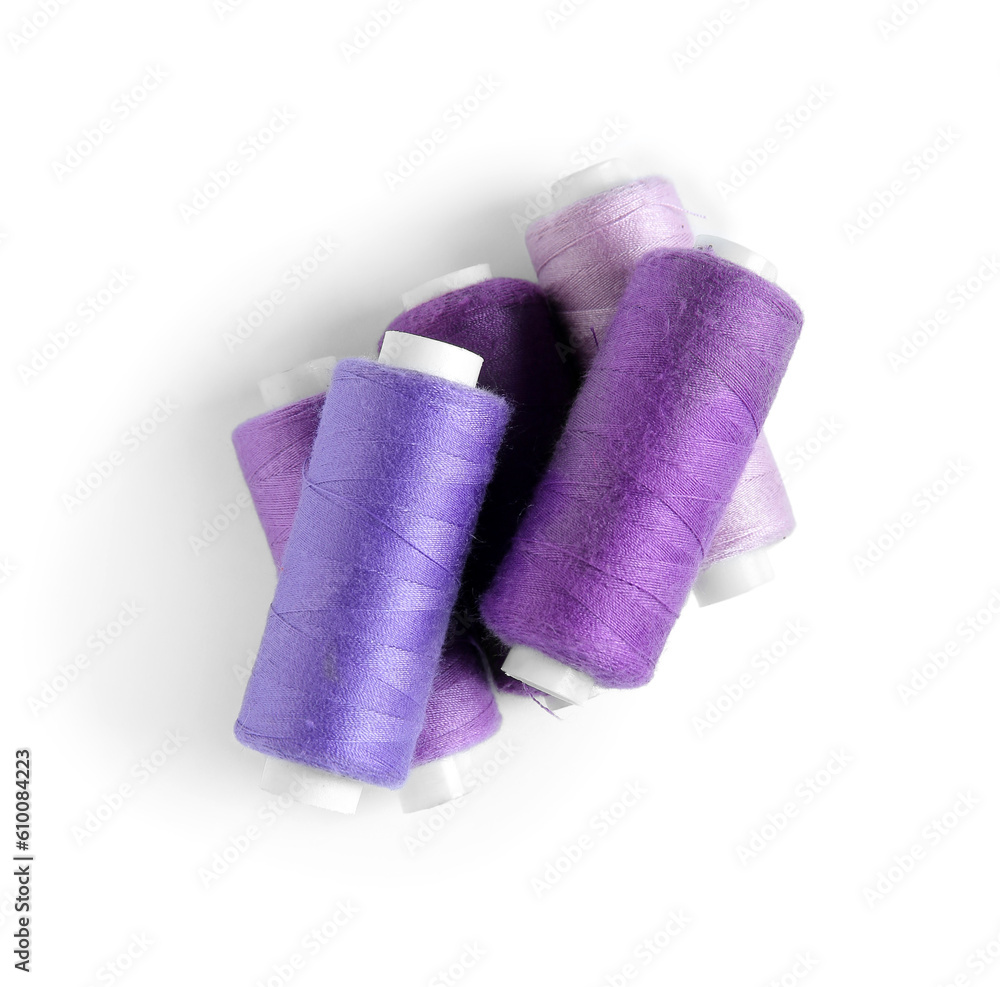 Set of different purple thread spools isolated on white background