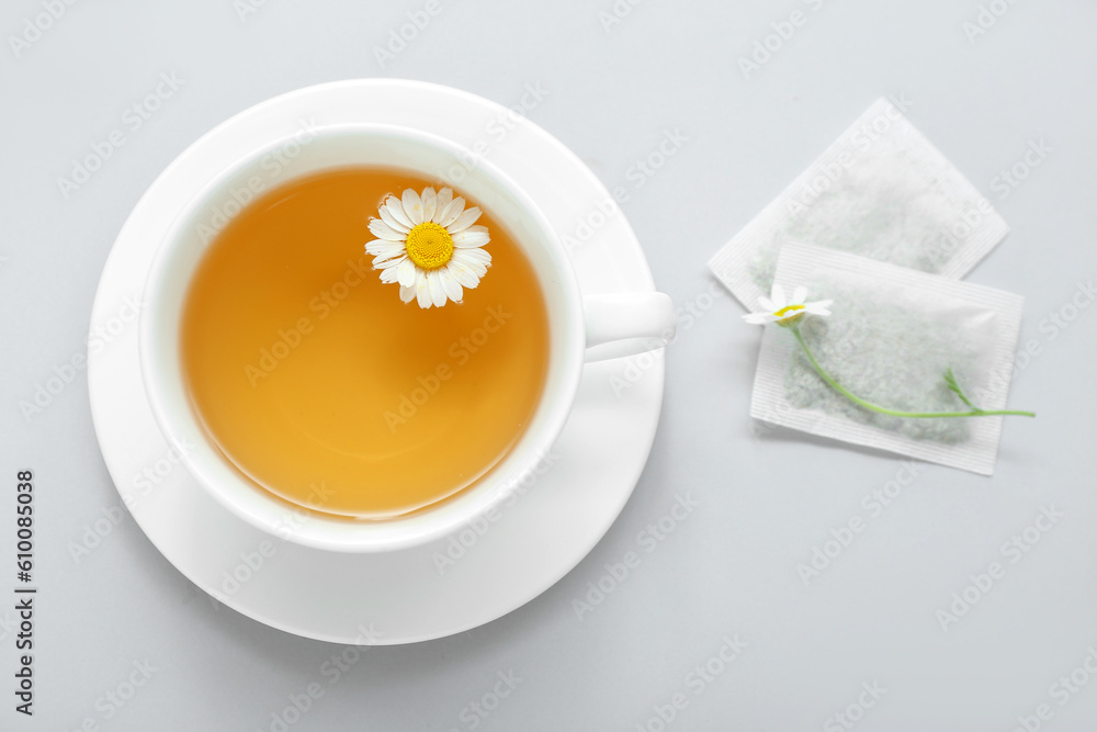 Cup of aromatic chamomile tea on white background