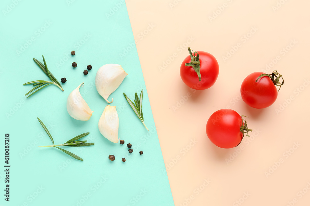 Composition with ripe cherry tomatoes, rosemary, garlic and peppercorn on color background