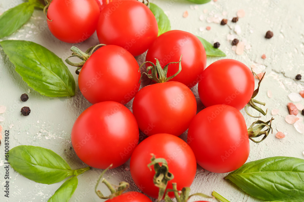 Composition with ripe cherry tomatoes, basil leaves and peppercorn on color background, closeup