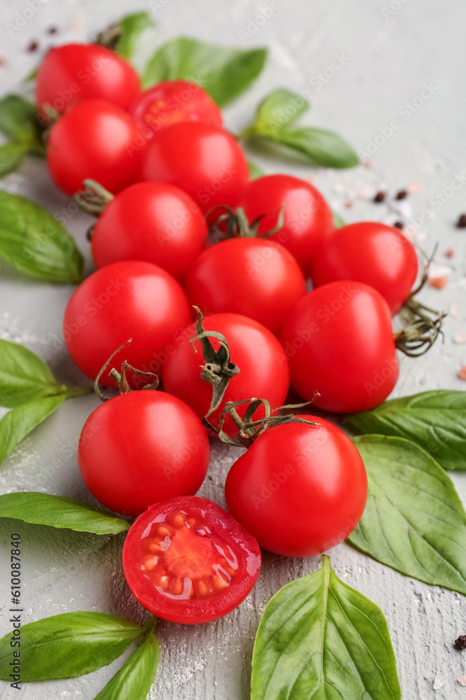 Composition with ripe cherry tomatoes, basil leaves and peppercorn on color background, closeup