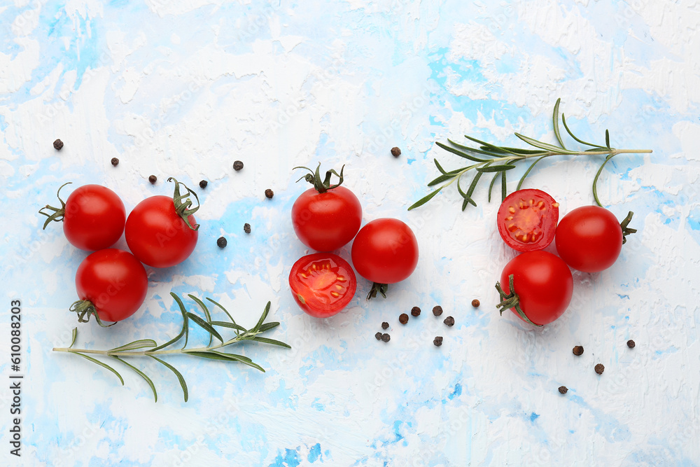 Composition with ripe cherry tomatoes and spices on blue background