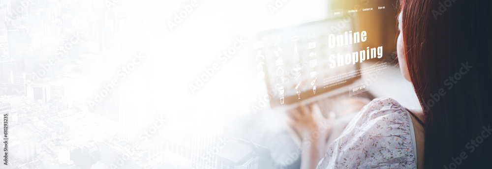 Woman using a laptop with typing on a keyboard with online shopping concept, Shopping cart part of t