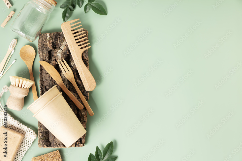 Set of eco-friendly tableware and cleaning products on pastel green background, flat lay stop plasti