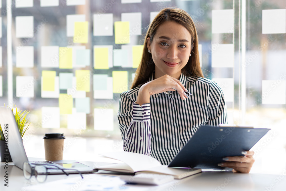 Attractive asian business woman secretary portrait at office desk.