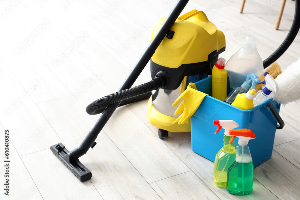 Bucket with cleaning supplies in kitchen