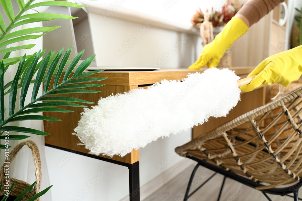 Housewife cleaning table with pp-duster at home, closeup