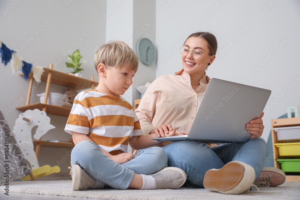 Nanny with little boy watching cartoons at home