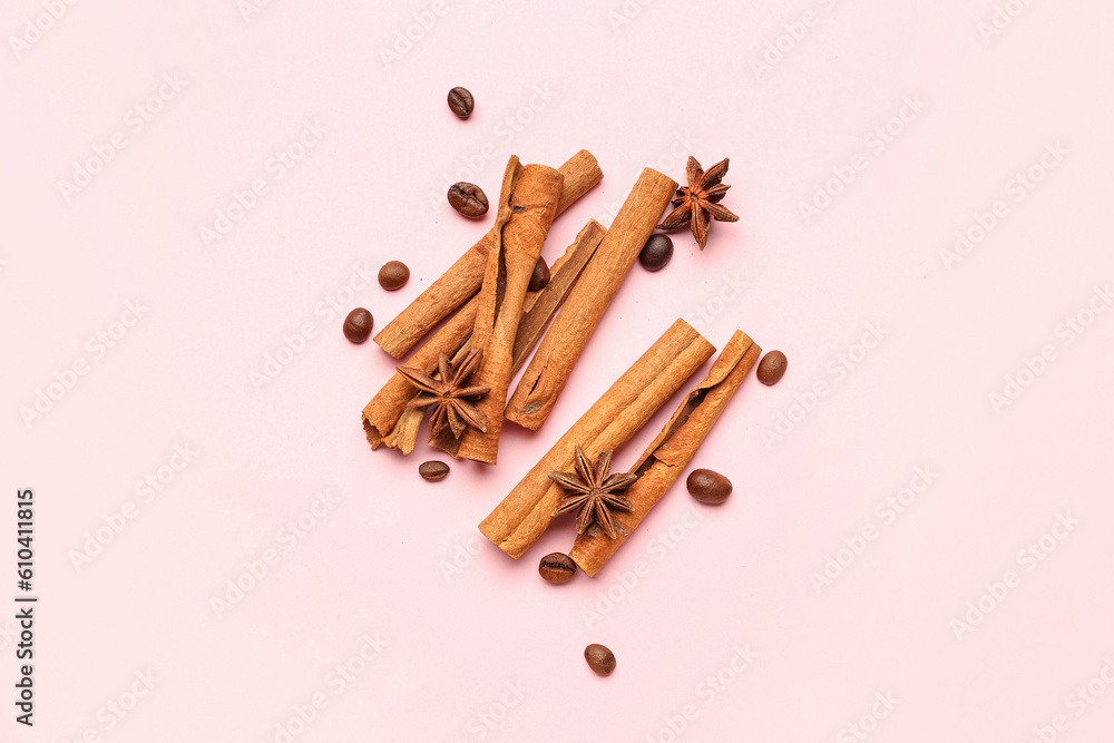 Cinnamon sticks, anise stars and coffee beans on pink background