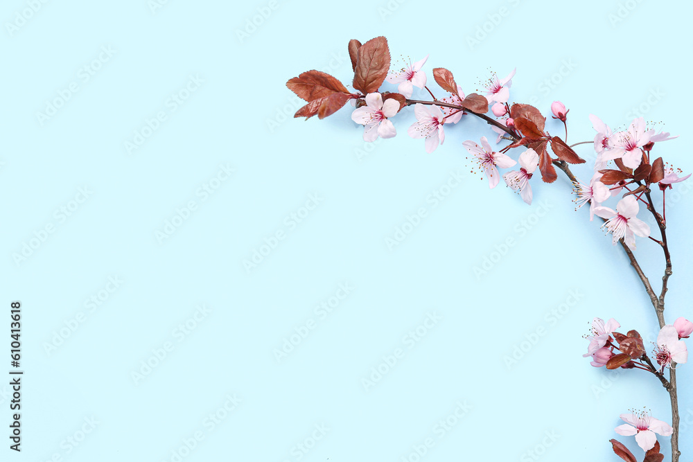 Blooming tree branch with pink flowers on blue background