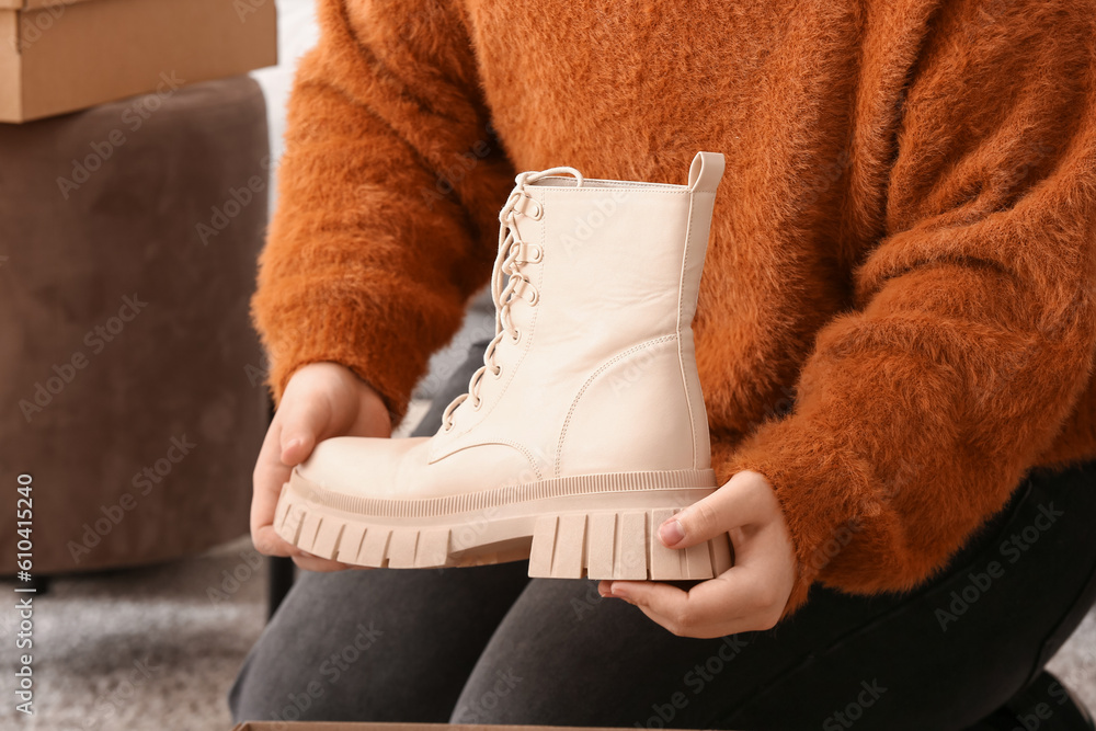 Woman holding beige boot in room