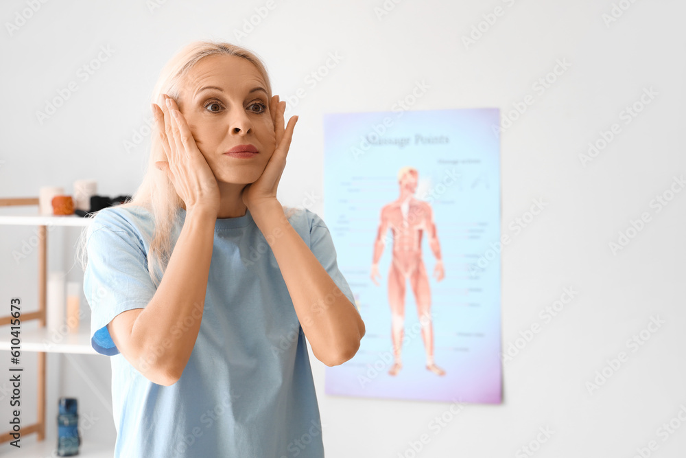 Mature physiotherapist doing face building exercise in rehabilitation center