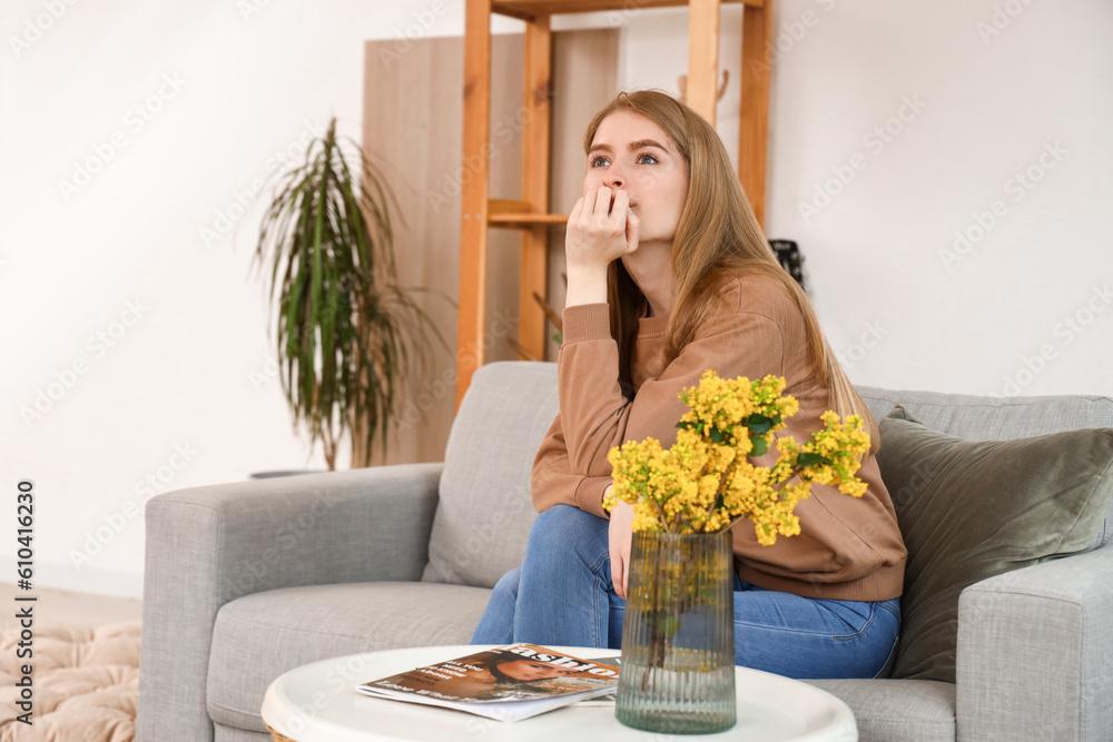 Dreaming young woman on sofa at home