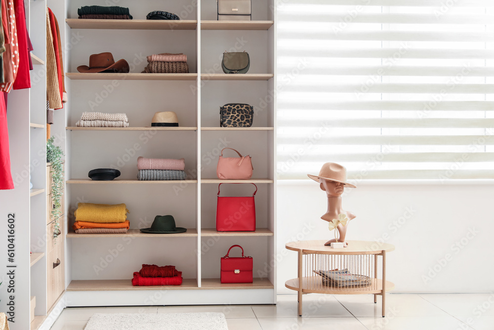 Shelves with stylish clothes and accessories in boutique