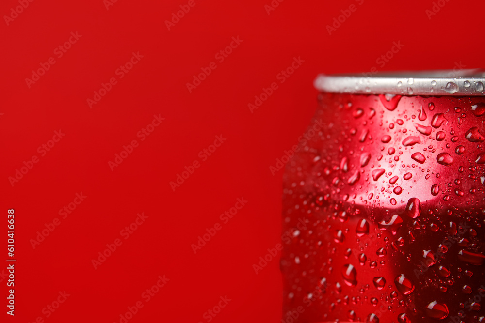 Can of fresh soda with water drops on red background, closeup