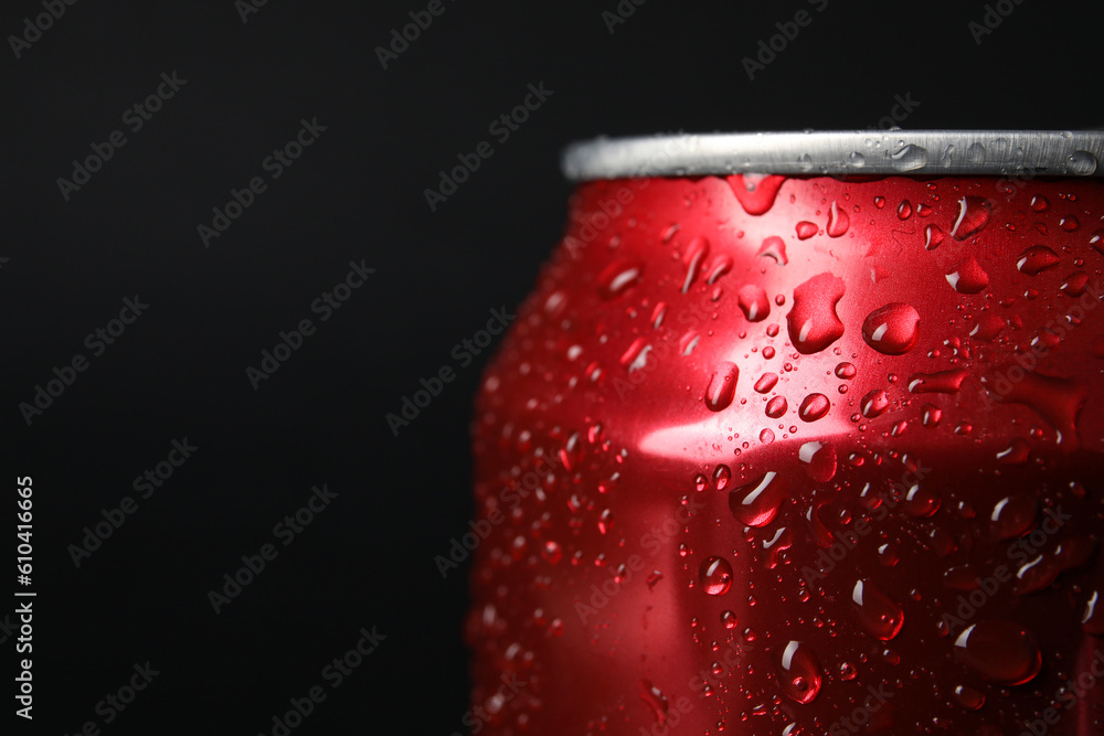 Red can of fresh soda with water drops on dark background, closeup