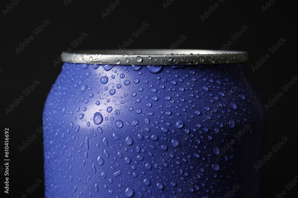 Lilac can of fresh soda with water drops on dark background, closeup