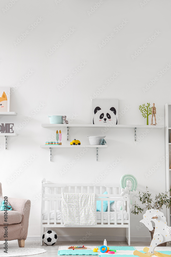 Stylish interior of childrens room with baby bed and toys