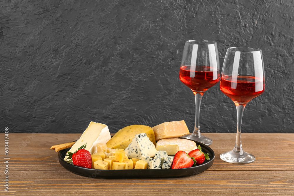 Pieces of tasty cheese and glasses with wine on table