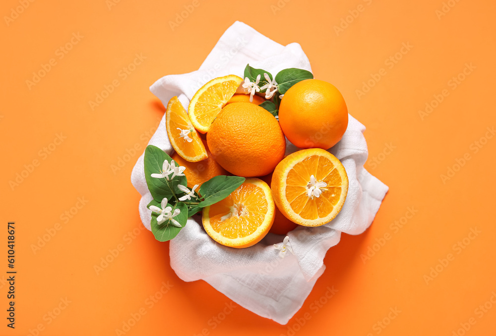 Bowl of oranges with blooming branch on color background