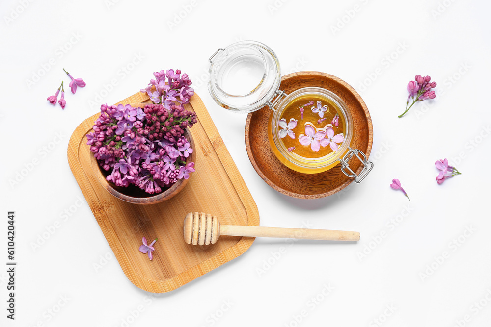 Jar of honey and lilac flowers with wooden board on white background