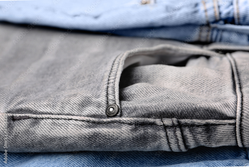 Different stylish denim jeans as background, closeup