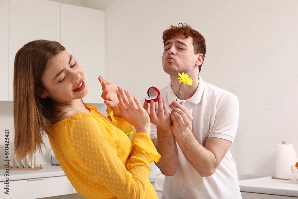 Young woman rejecting marriage proposal from her boyfriend in kitchen