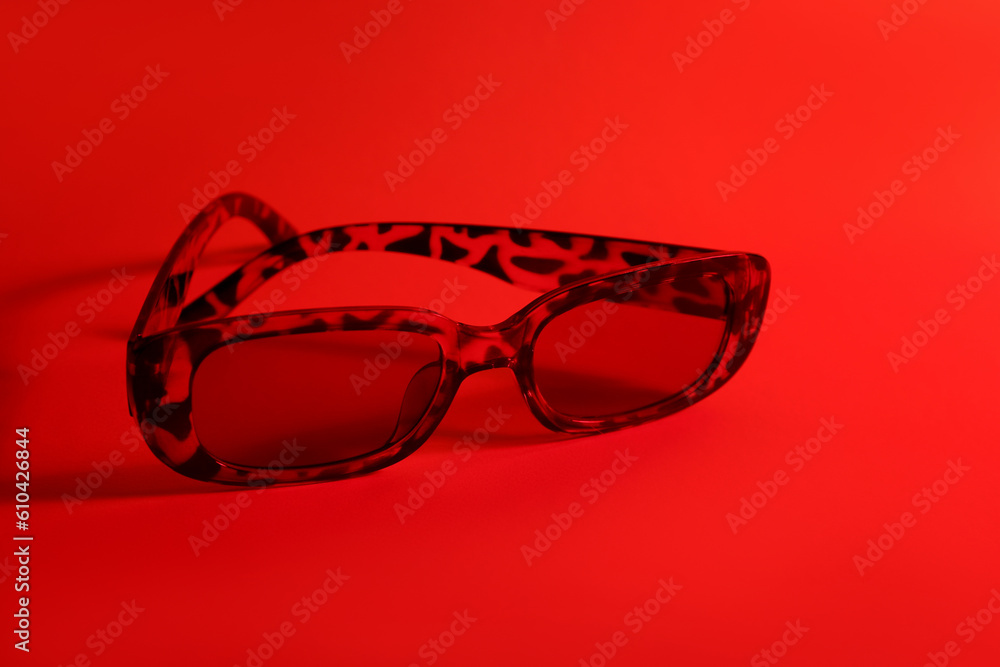 Leopard print sunglasses on red background