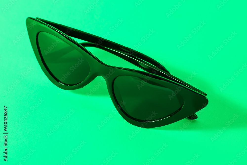 Stylish black sunglasses on turquoise background