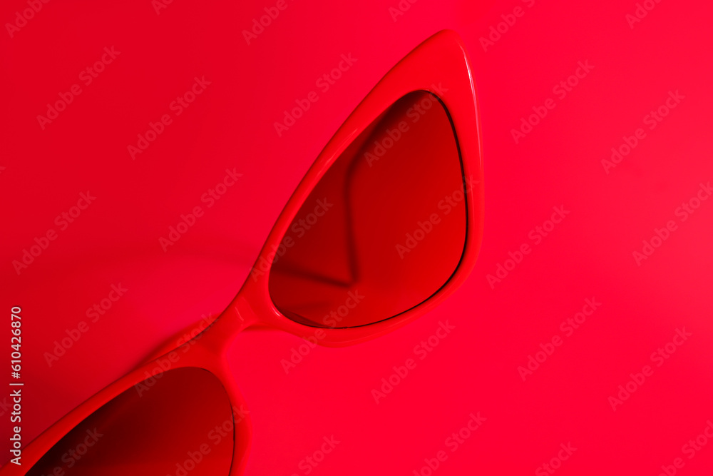 Stylish sunglasses on red background