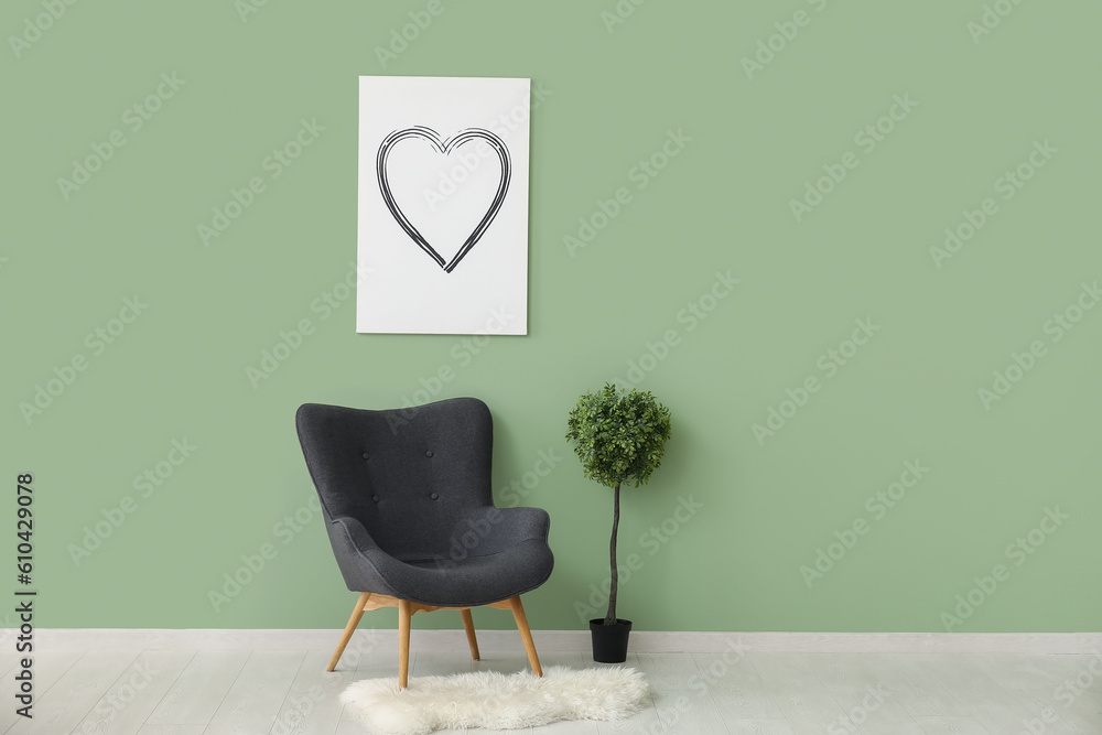 Dark grey armchair with houseplant and fluffy rug near green wall