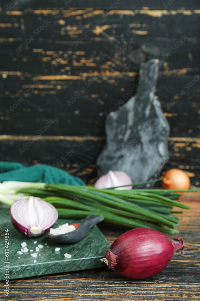 Boards with different kinds of onion and spices on brown wooden background