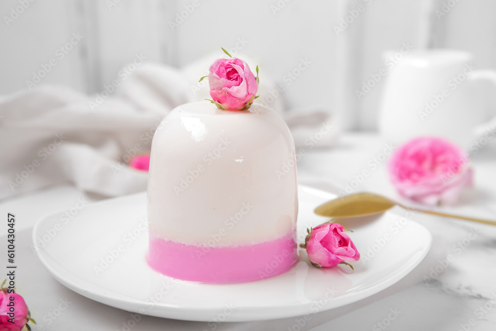 Plate of panna cotta with beautiful pink rose flowers on white table