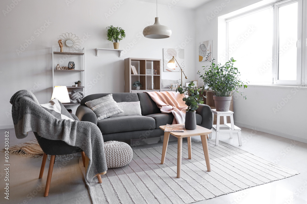 Interior of living room with glowing lamps, sofa and armchair