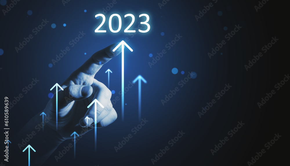 Toned businessman hands pointing at growing upward 2023 arrows on dark background. Company growth, a