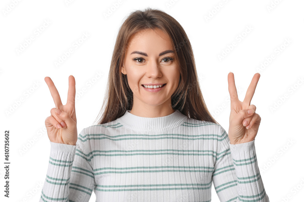 Beautiful woman in striped shirt showing victory gesture on white background