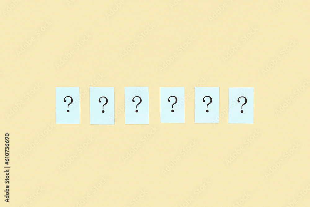 Papers with question marks on yellow background