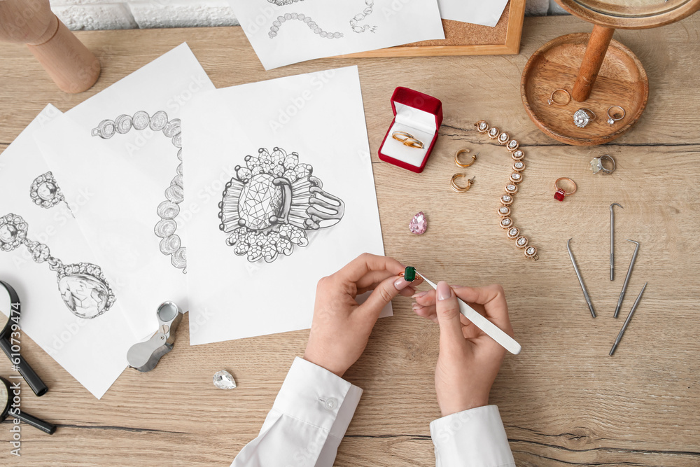 Female jeweler making ring on wooden table, top view