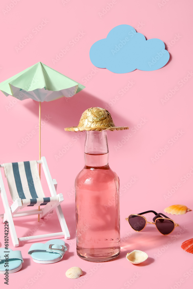 Bottle of soda with beach decor on pink background