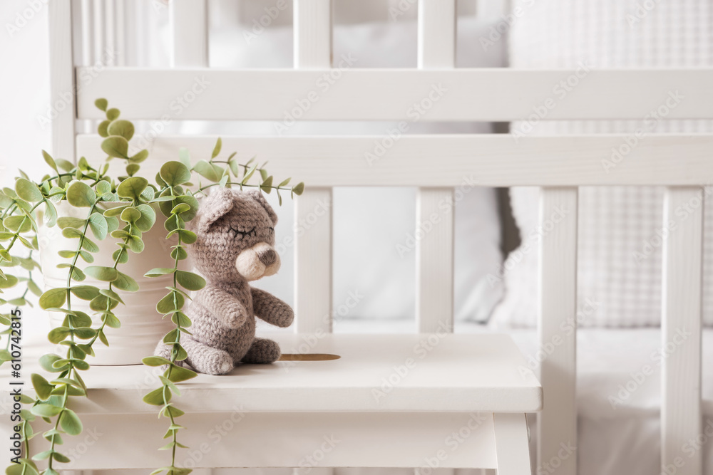 Toy with houseplant on stool in childrens bedroom, closeup