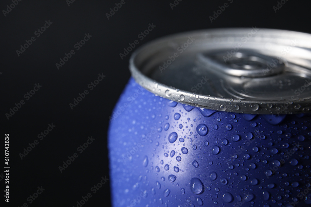 Lilac can of fresh soda with water drops on dark background, closeup