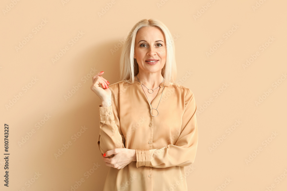 Mature blonde woman on beige background